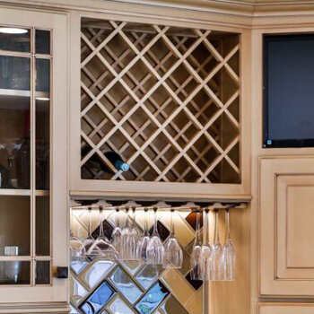 An open diamond patterned wine rack cabinet from Dura Supreme Cabinetry with a wine glass rack below.